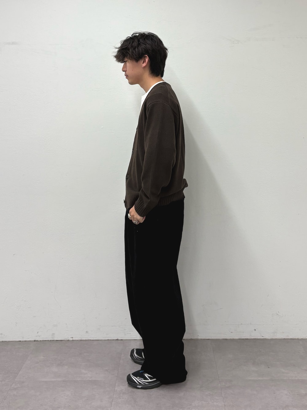 ブラウン系のカーディガン/ボレロ、ホワイト系のTシャツ/カットソー、ブラック系のデニムパンツを着用したメンズの秋コーディネートの2枚目の写真