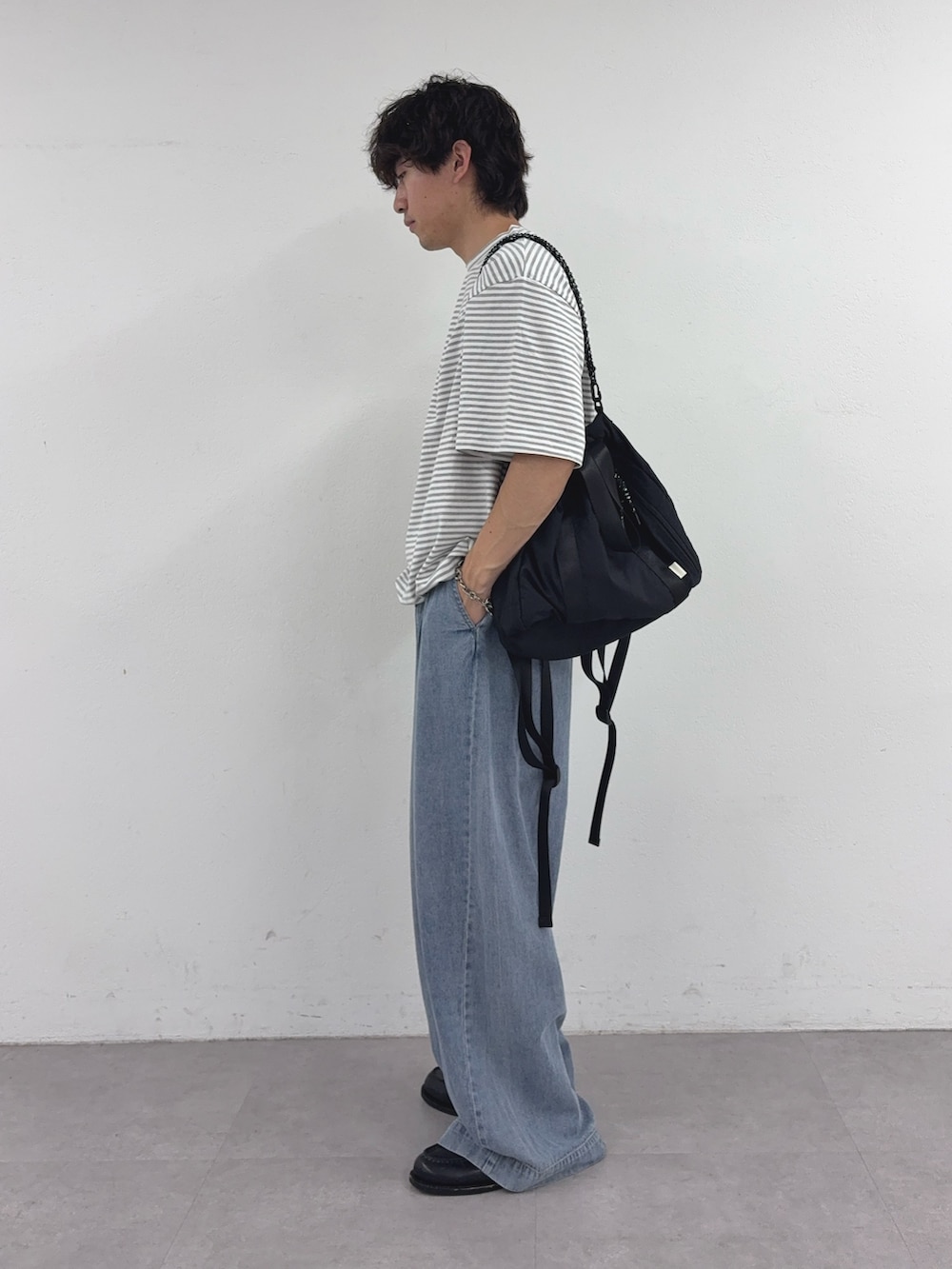 グレー系のTシャツ/カットソー、ブラック系のトートバッグ、ブルー系のデニムパンツを着用したメンズの夏コーディネートの2枚目の写真