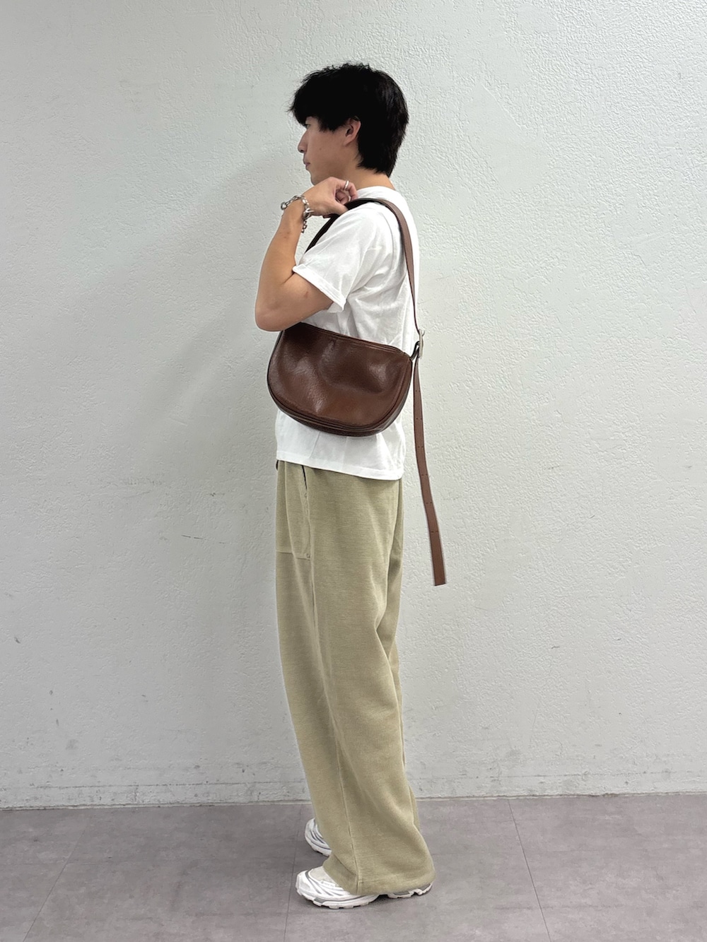 ホワイト系のTシャツ/カットソー、ブラウン系のショルダーバッグ、ベージュ系のスウェットパンツを着用したメンズの夏コーディネートの2枚目の写真