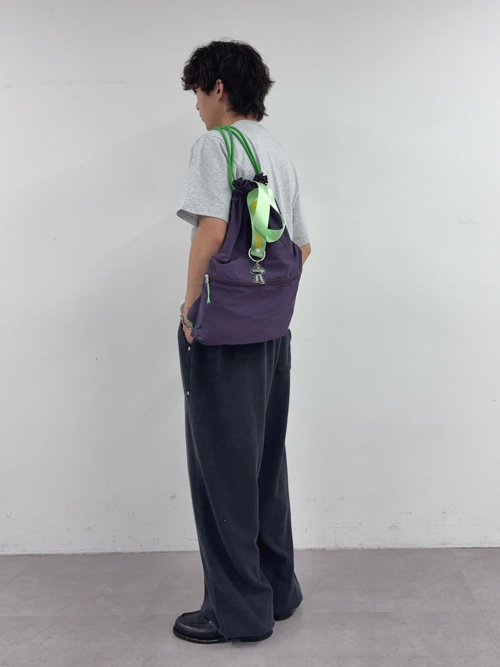 グレー系のTシャツ/カットソー、パープル系のバックパック/リュック、ブラック系のスウェットパンツを着用したメンズの春コーディネートの2枚目の写真