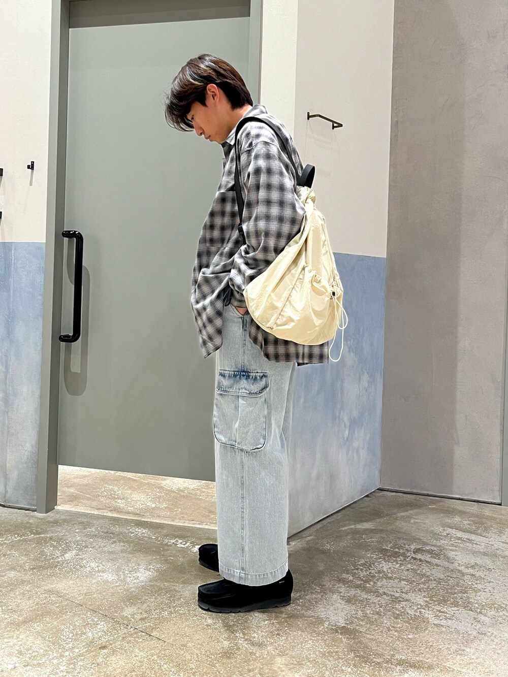 ブラック系のスニーカー、ブルー系のカーゴパンツ、ブラック系のシャツ/ブラウスを着用したメンズの春コーディネートの3枚目の写真