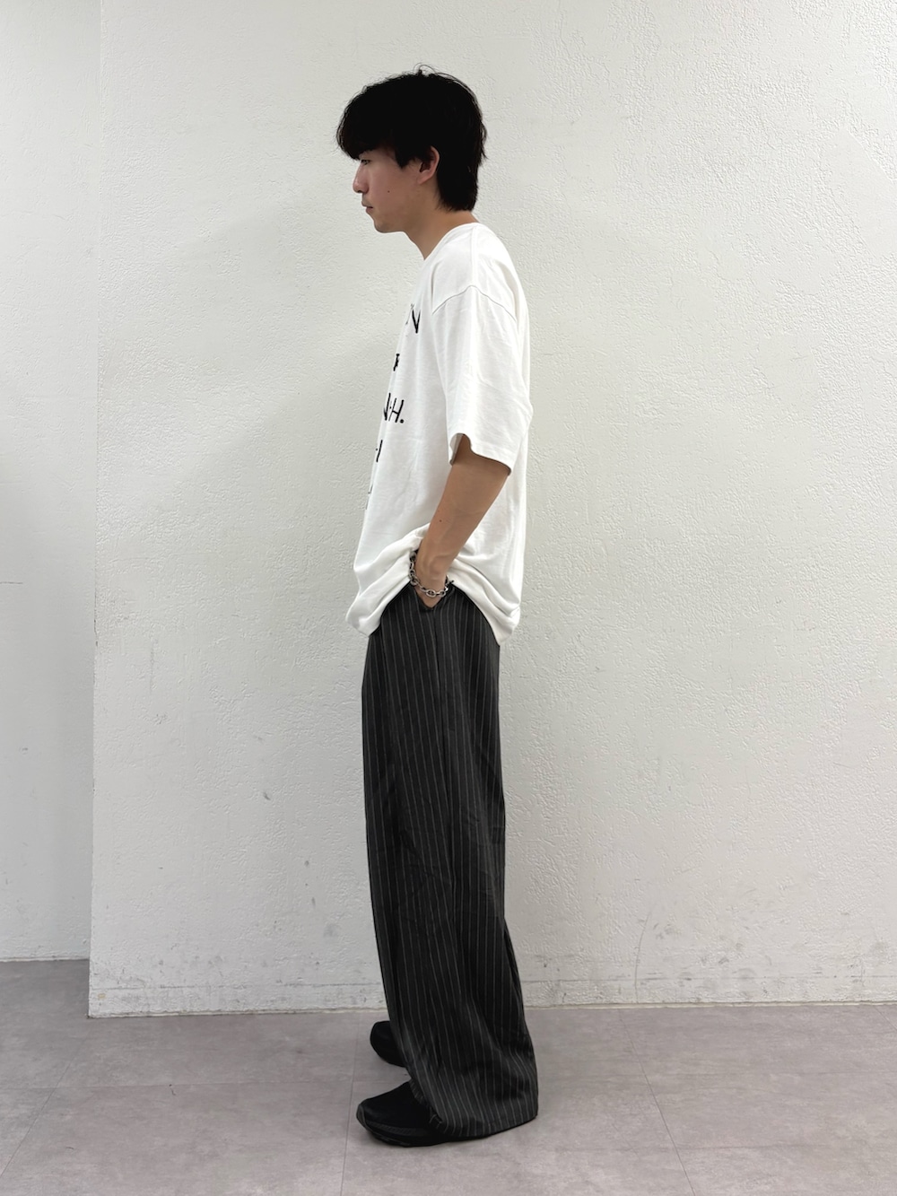 ホワイト系のTシャツ/カットソー、グレー系のスラックスを着用したメンズの夏コーディネートの2枚目の写真