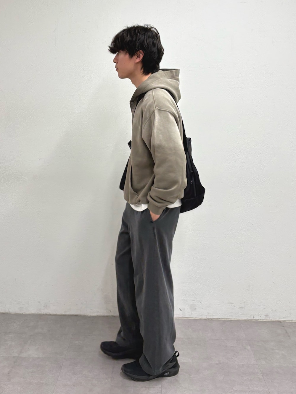ベージュ系のパーカー、グレー系のその他パンツ、ブラック系のショルダーバッグを着用したメンズの冬コーディネートの2枚目の写真