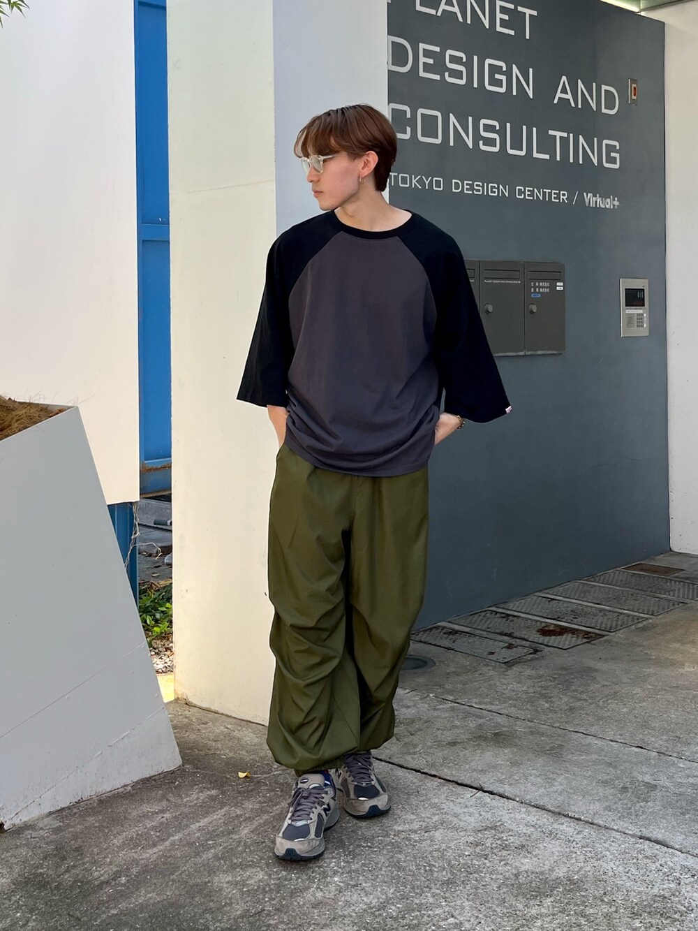 ブラック系のTシャツ/カットソー、グリーン系のカーゴパンツ、グレー系のスニーカーを着用したメンズの夏コーディネートの3枚目の写真