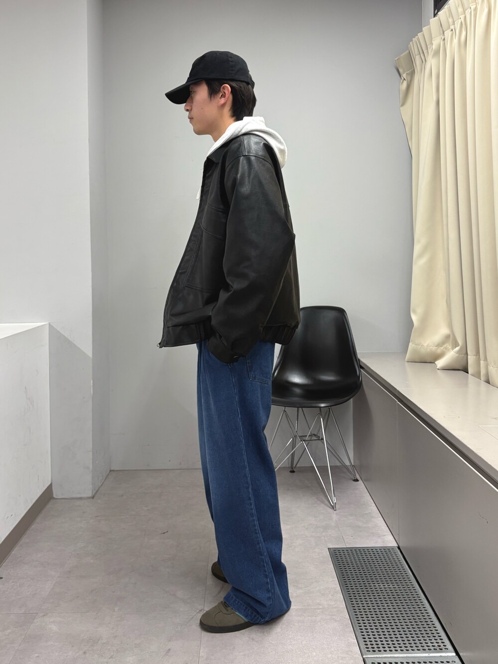 ブラック系のライダースジャケット、グレー系のパーカー、ブルー系のデニムパンツを着用したメンズの秋コーディネートの2枚目の写真