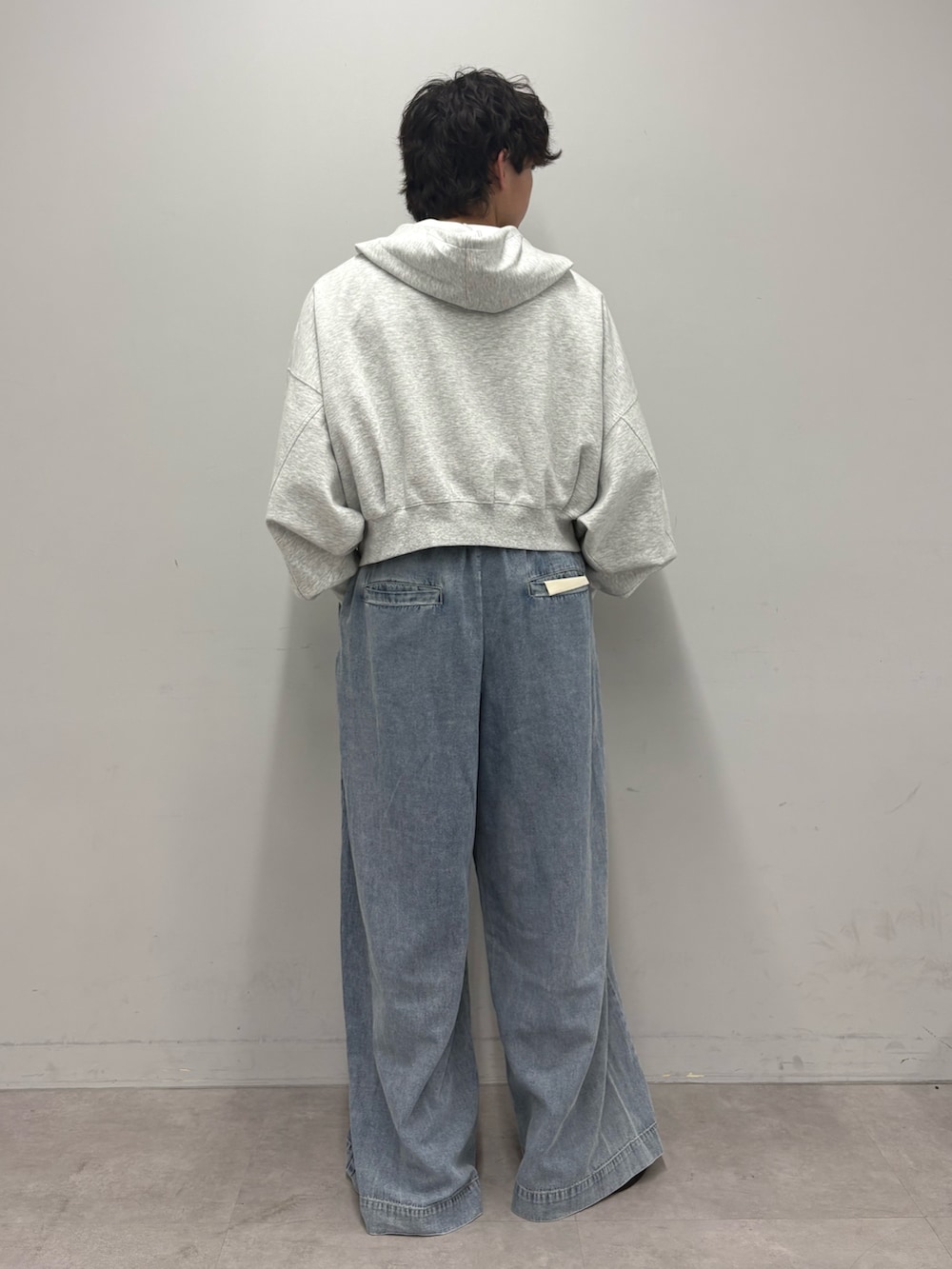 グレー系のパーカー、ブルー系のデニムパンツを着用したメンズの春コーディネートの3枚目の写真