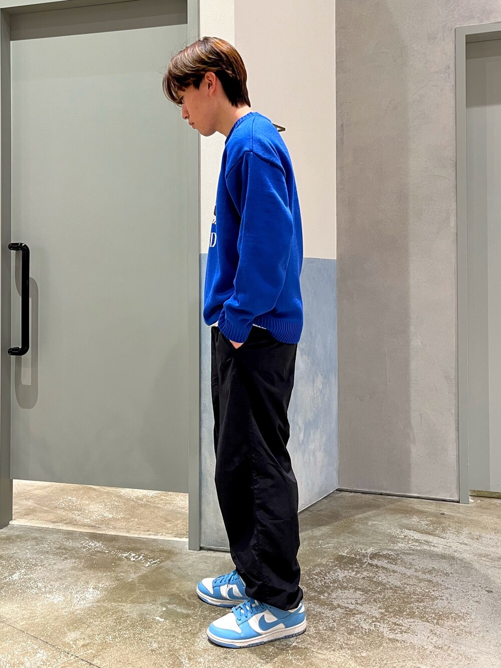 ブルー系のスニーカー、ブラック系のその他パンツ、ブルー系のニット/セーターを着用したメンズの冬コーディネートの2枚目の写真