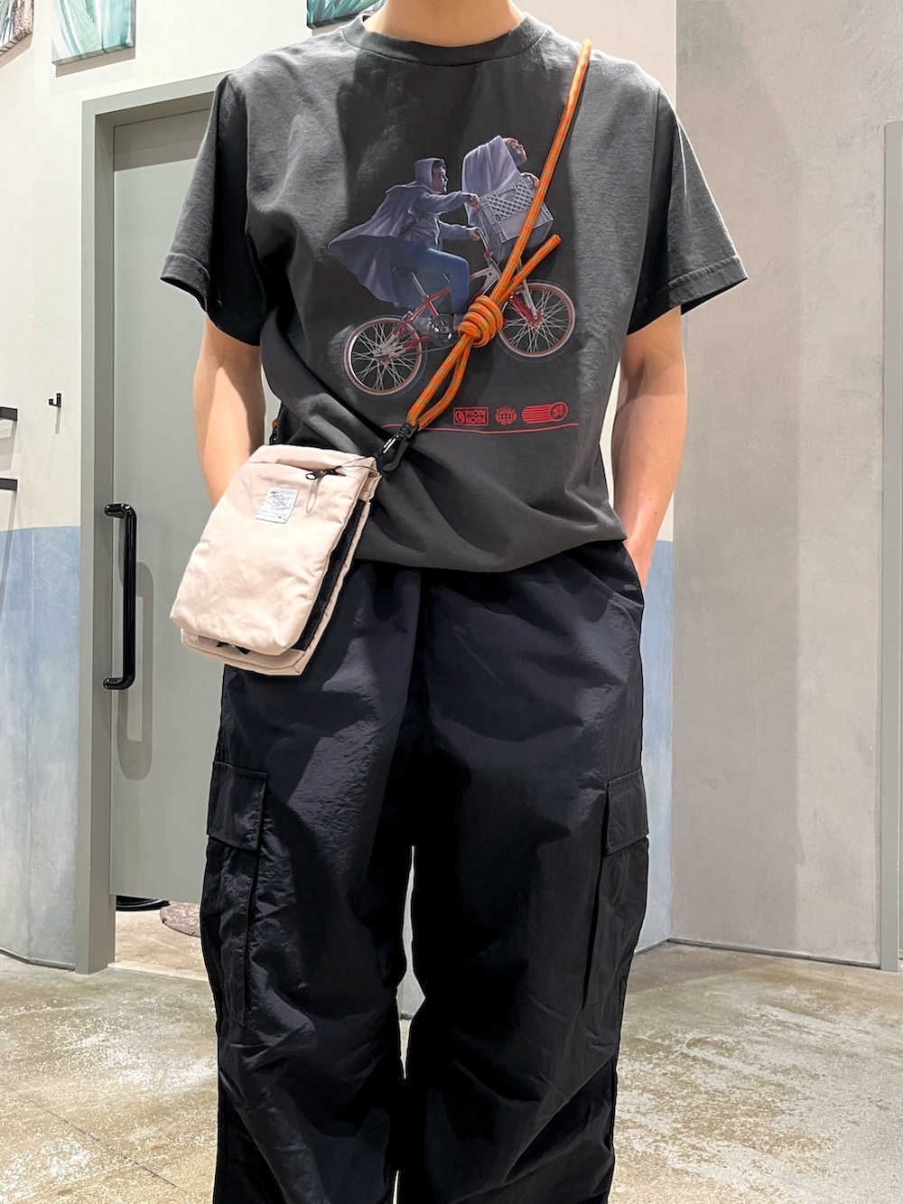 ブラック系のカーゴパンツ、グレー系のスニーカー、ブラック系のTシャツ/カットソーを着用したメンズの夏コーディネートの3枚目の写真