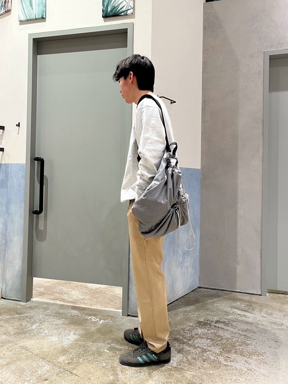 グレー系のスニーカー、ベージュ系のデニムパンツ、グレー系のスウェットを着用したメンズの春コーディネートの2枚目の写真