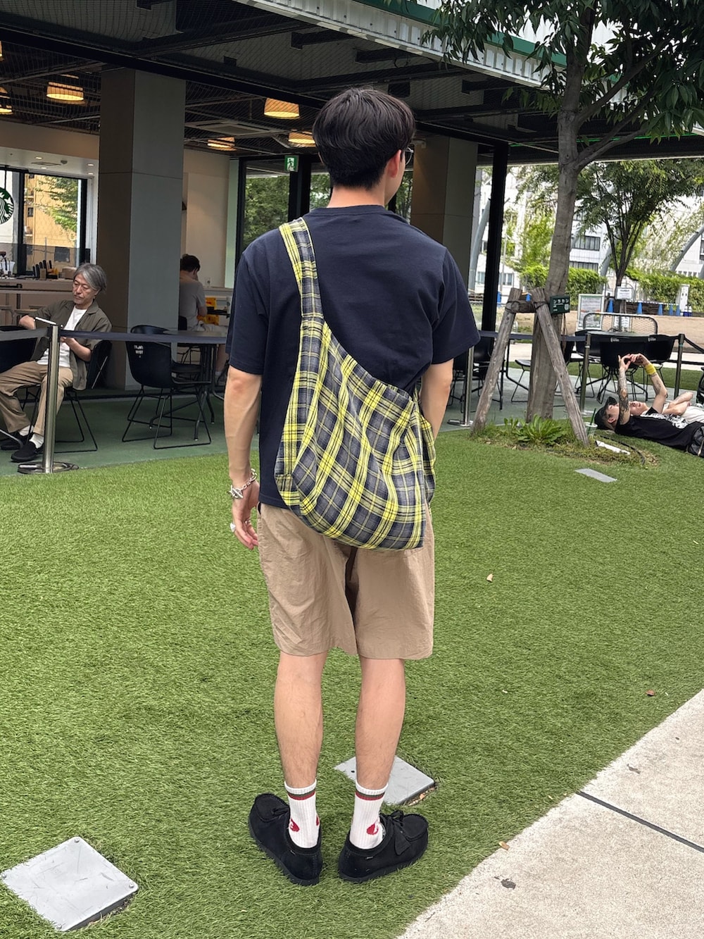 ブルー系のTシャツ/カットソー、イエロー系のショルダーバッグ、ベージュ系のその他パンツを着用したメンズの夏コーディネートの2枚目の写真