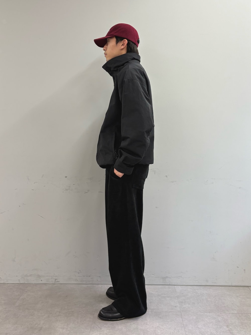 ブラック系のナイロンジャケット、ブラック系のその他パンツ、レッド系のキャップを着用したメンズの冬コーディネートの2枚目の写真