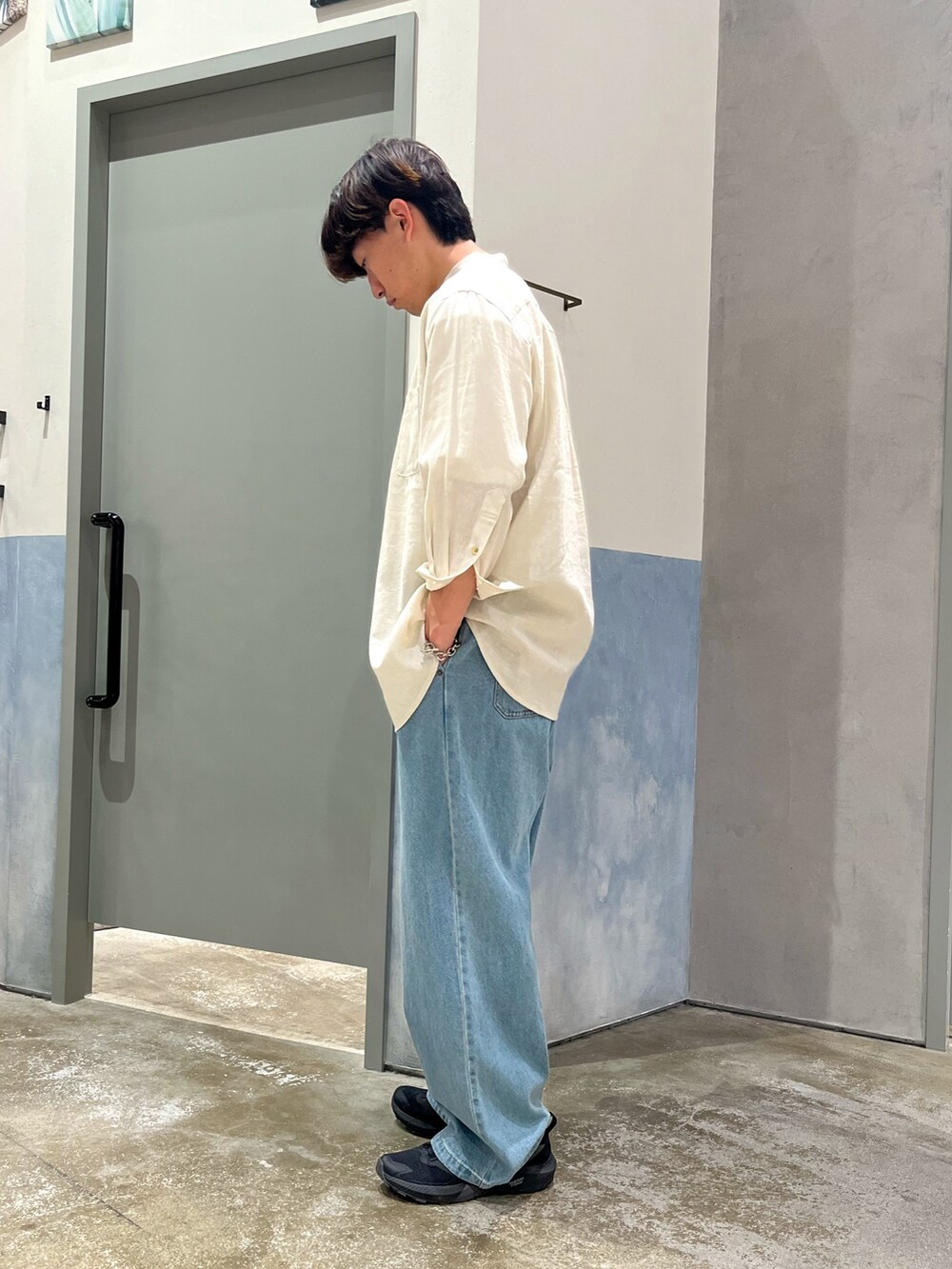 ブラック系のスニーカー、ブルー系のデニムパンツ、ベージュ系のシャツ/ブラウスを着用したメンズの春コーディネートの2枚目の写真