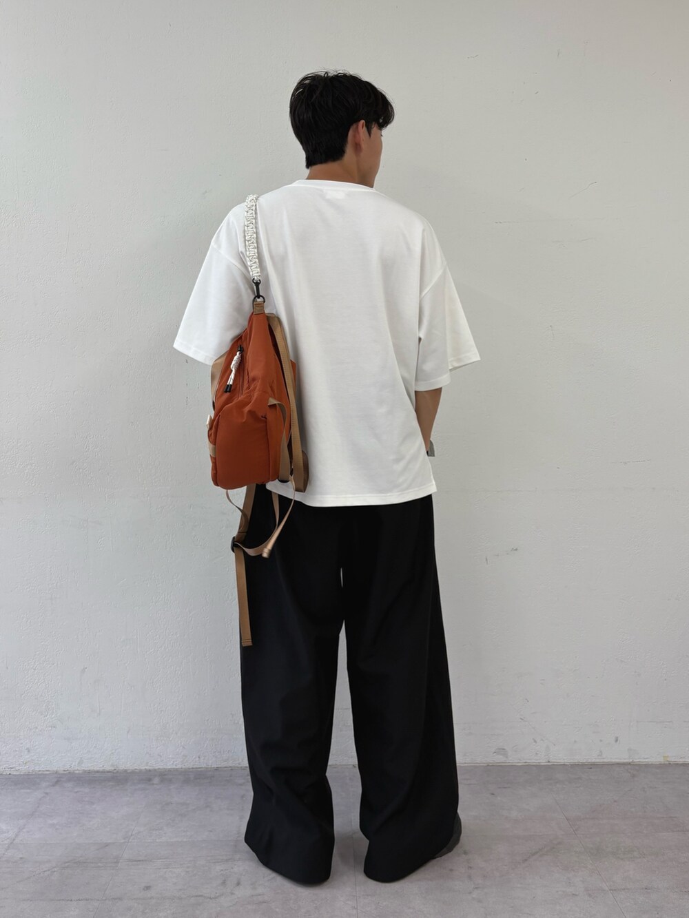 ホワイト系のTシャツ/カットソー、ブラック系のスラックスを着用したメンズの秋コーディネートの2枚目の写真