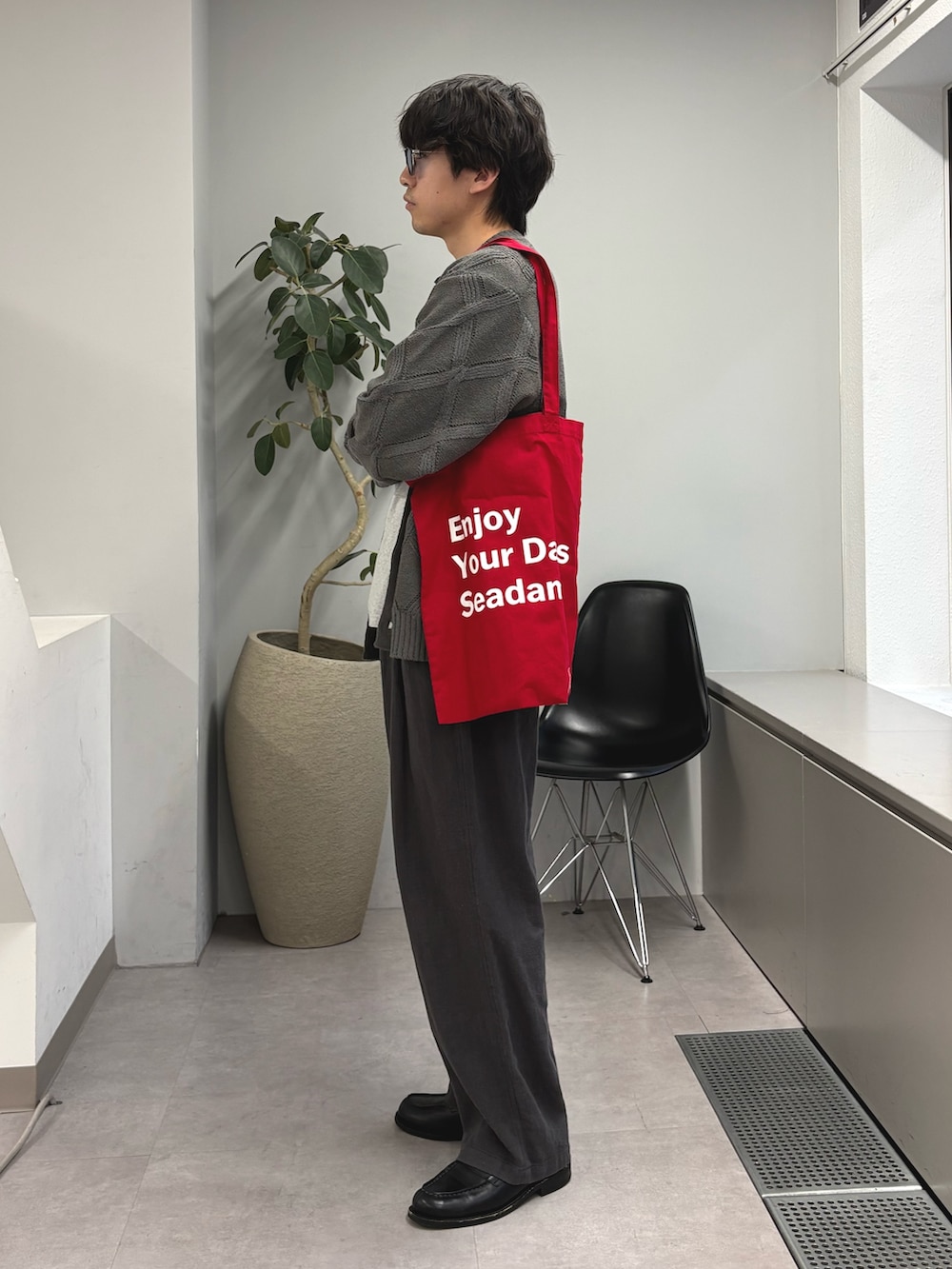 グレー系のカーディガン/ボレロ、グレー系のTシャツ/カットソー、レッド系のトートバッグを着用したメンズの春コーディネートの2枚目の写真