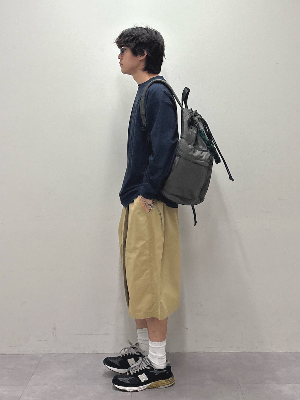 ブルー系のTシャツ/カットソー、グレー系のバックパック/リュック、ベージュ系のその他パンツを着用したメンズの夏コーディネートの2枚目の写真