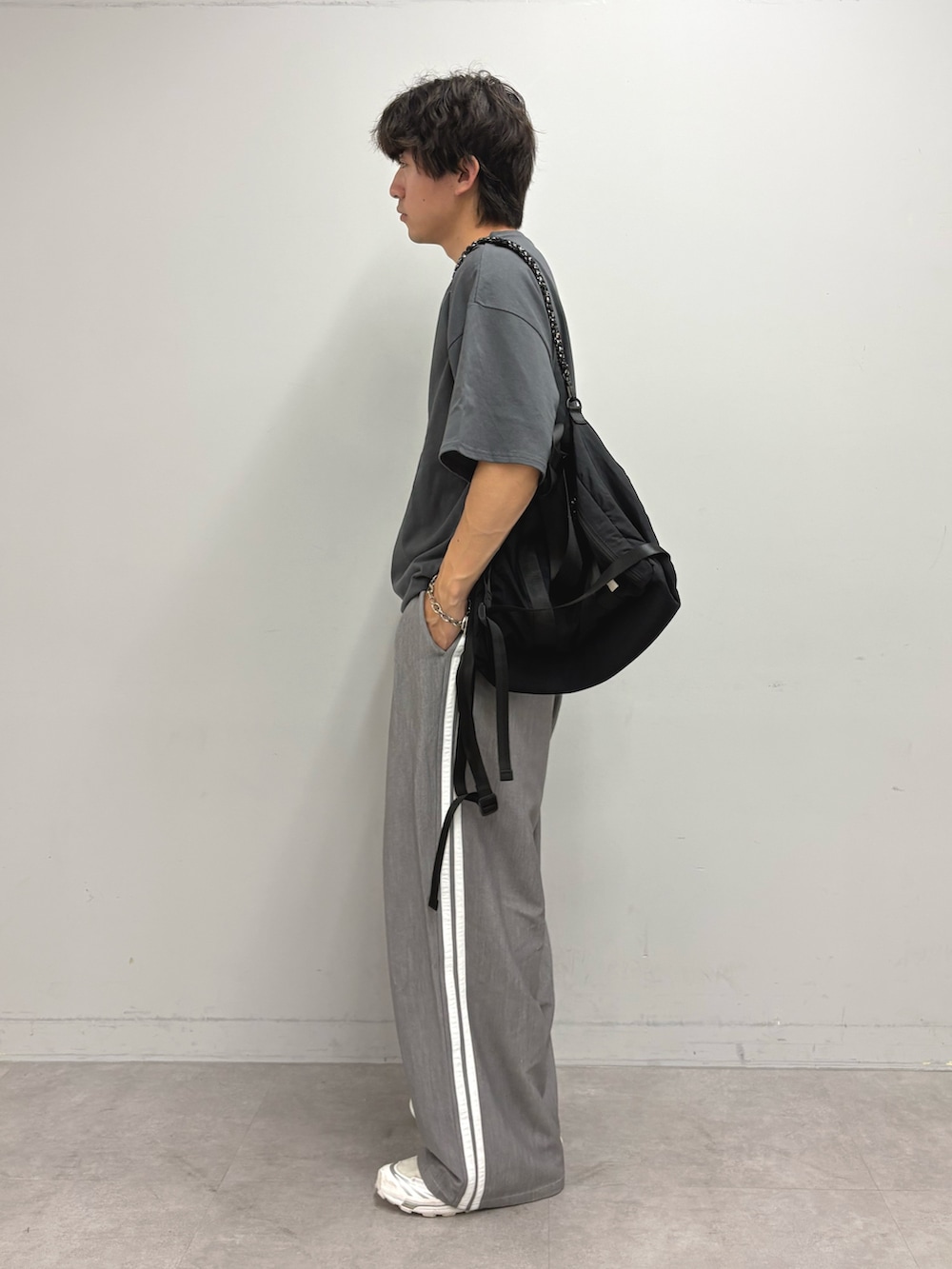 グレー系のTシャツ/カットソー、ブラック系のトートバッグ、グレー系のスラックスを着用したメンズの夏コーディネートの2枚目の写真