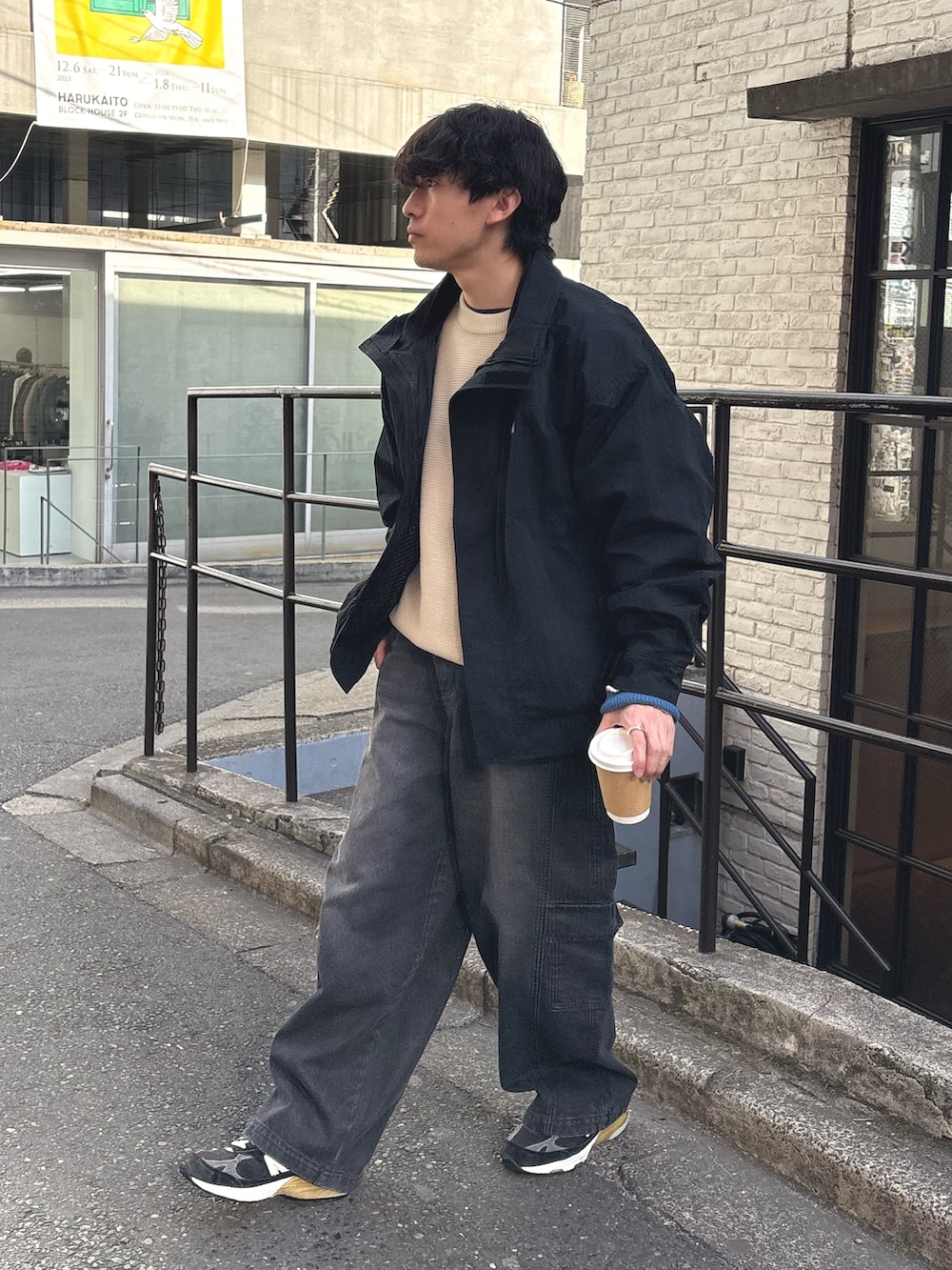 ブラック系のナイロンジャケット、ホワイト系のニット/セーター、ブラック系のカーゴパンツを着用したメンズの冬コーディネートの2枚目の写真