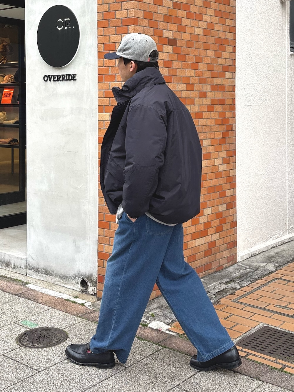 ブラック系のダウンジャケット/コート、グレー系のシャツ/ブラウス、ブルー系のデニムパンツを着用したメンズの冬コーディネートの2枚目の写真