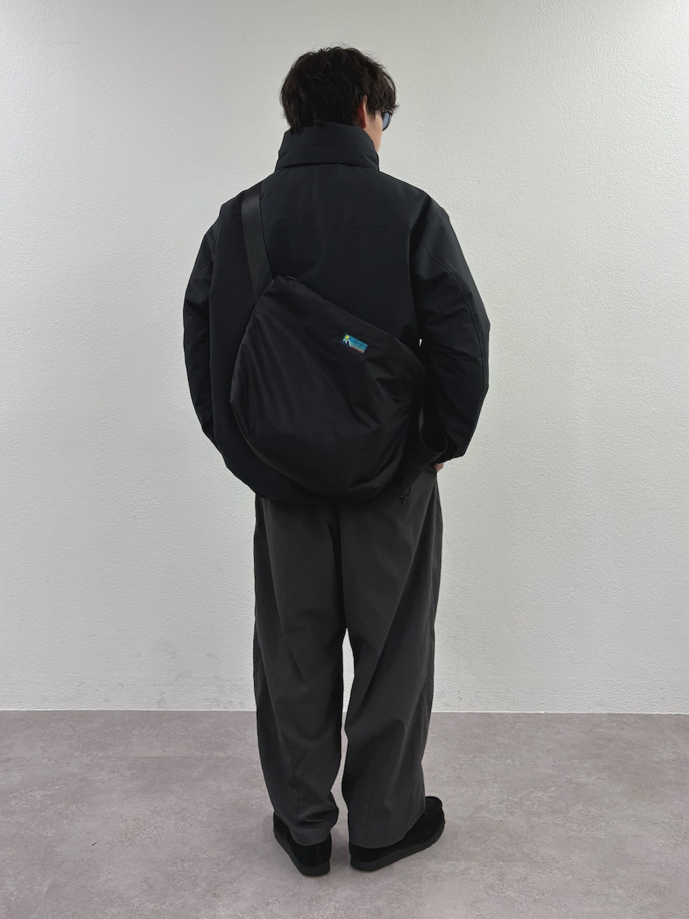 ブラック系のダウンジャケット/コート、グレー系のテーラードジャケット、ブラック系のショルダーバッグを着用したメンズの冬コーディネートの3枚目の写真