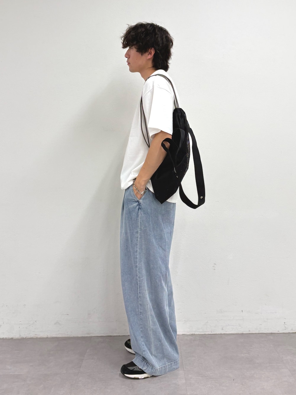 ホワイト系のTシャツ/カットソー、ブラック系のトートバッグ、ブルー系のデニムパンツを着用したメンズの夏コーディネートの2枚目の写真