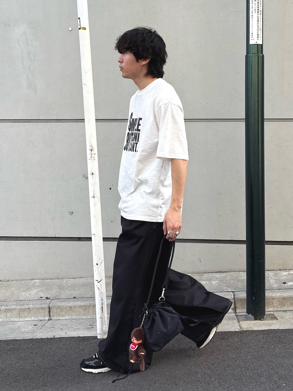 ホワイト系のTシャツ/カットソー、ブラック系のチノパンツを着用したメンズの春コーディネートの2枚目の写真