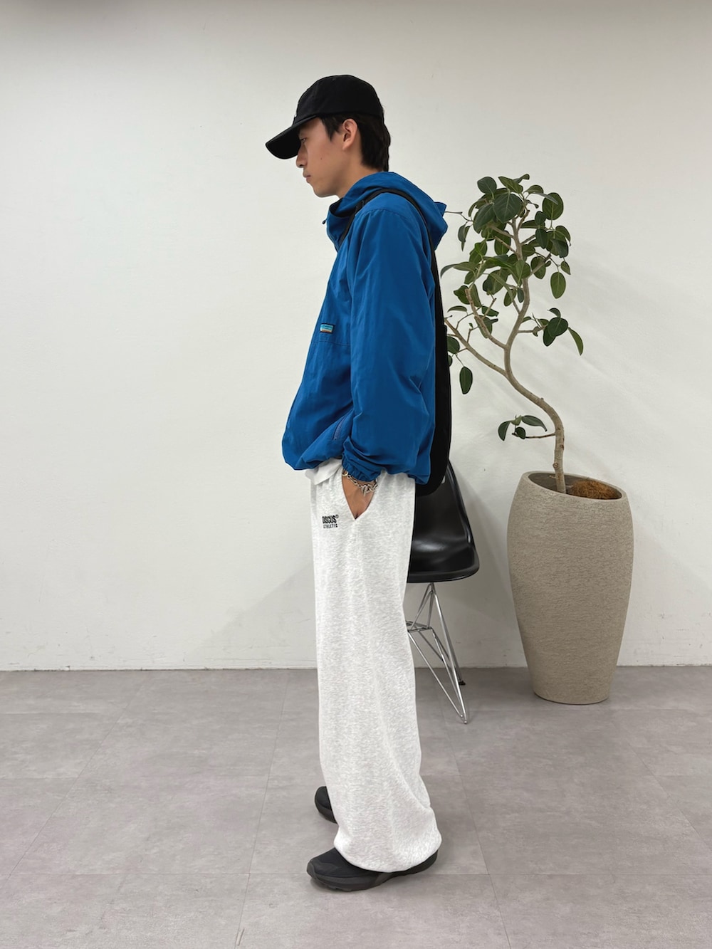 ブルー系のパーカー、ブラック系のショルダーバッグ、グレー系のスウェットパンツを着用したメンズの夏コーディネートの3枚目の写真