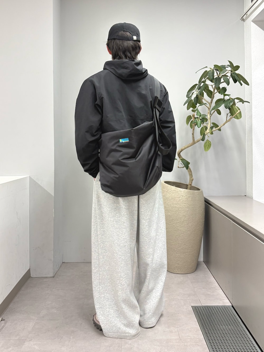 ブラック系のパーカー、ブラック系のショルダーバッグ、グレー系のその他パンツを着用したメンズの冬コーディネートの2枚目の写真