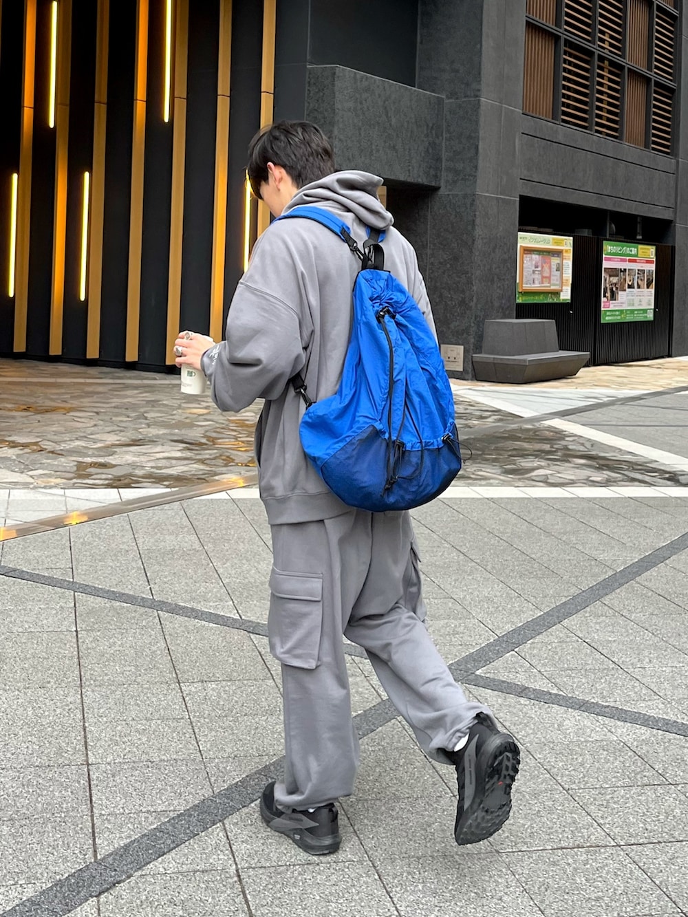 ブラック系のスニーカー、グレー系のトップス、ブルー系のバックパック/リュックを着用したメンズの冬コーディネートの3枚目の写真