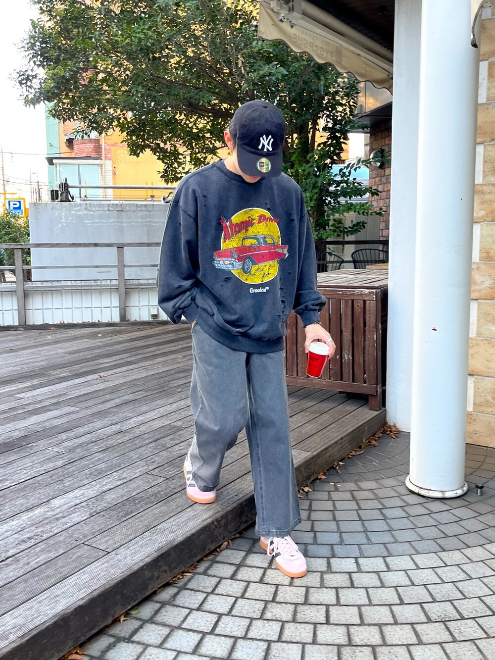 ブラック系のTシャツ/カットソー、ブラック系のデニムパンツ、ピンク系のスニーカーを着用したメンズの秋コーディネートの3枚目の写真