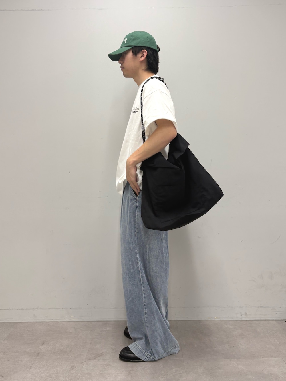 ホワイト系のTシャツ/カットソー、ブラック系のショルダーバッグ、ブルー系のデニムパンツを着用したメンズの夏コーディネートの2枚目の写真
