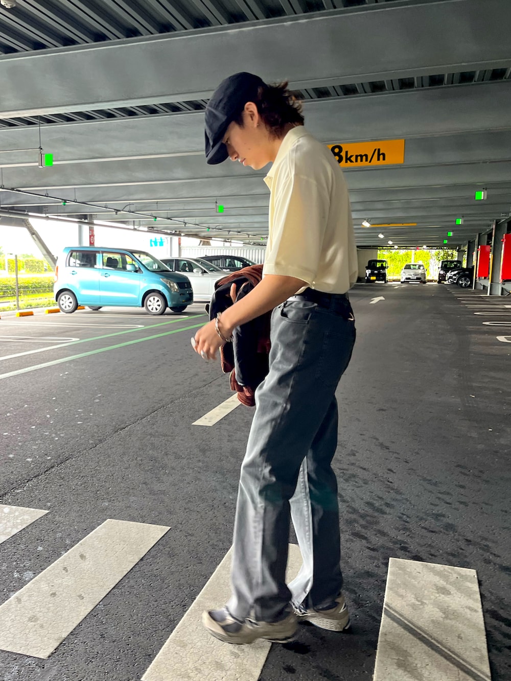 ホワイト系のポロシャツ、グレー系のその他パンツ、グレー系のスニーカーを着用したメンズの夏コーディネートの3枚目の写真