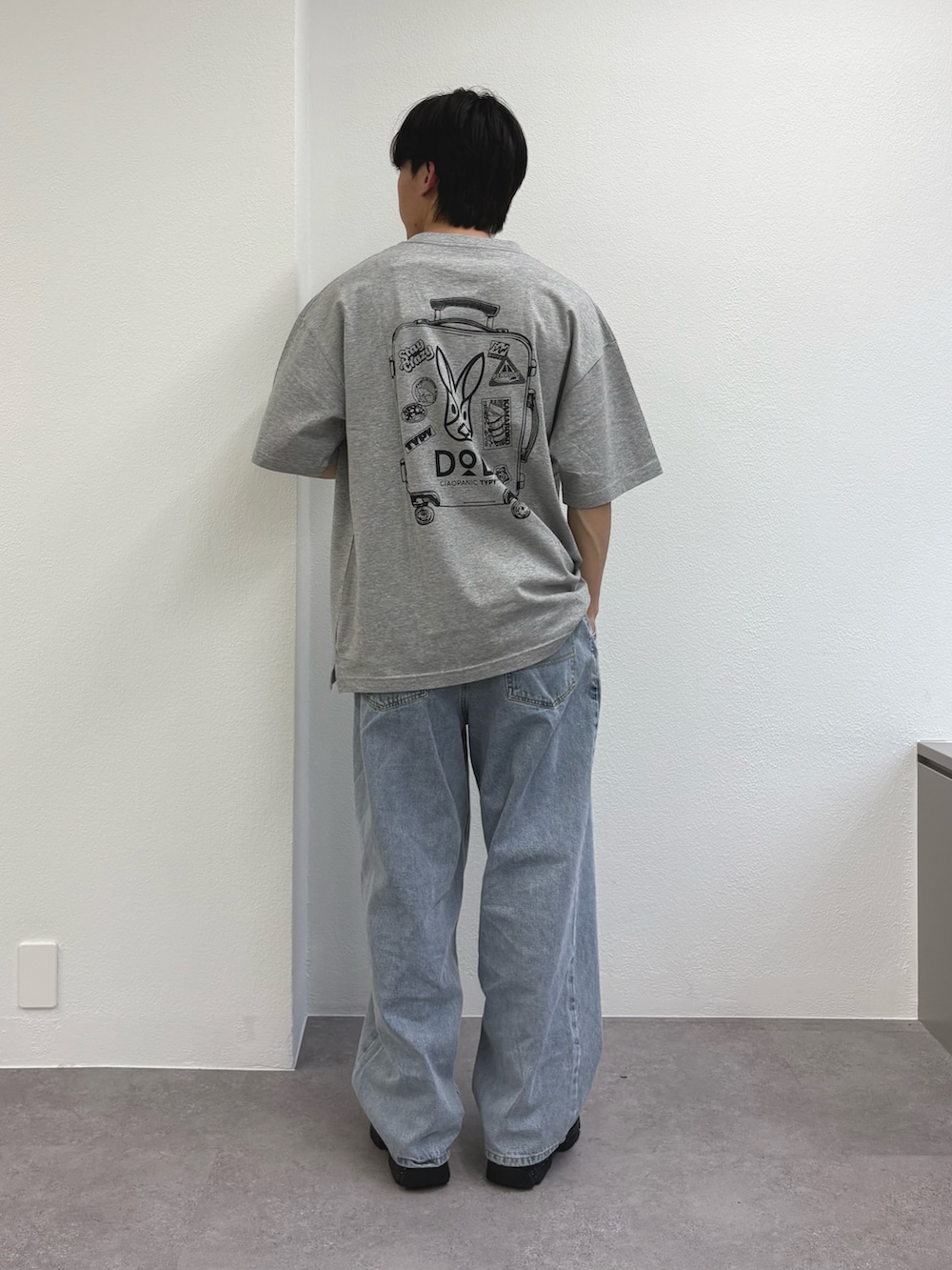 グレー系のTシャツ/カットソー、ブルー系のデニムパンツ、ブラック系のスニーカーを着用したメンズの春コーディネートの2枚目の写真