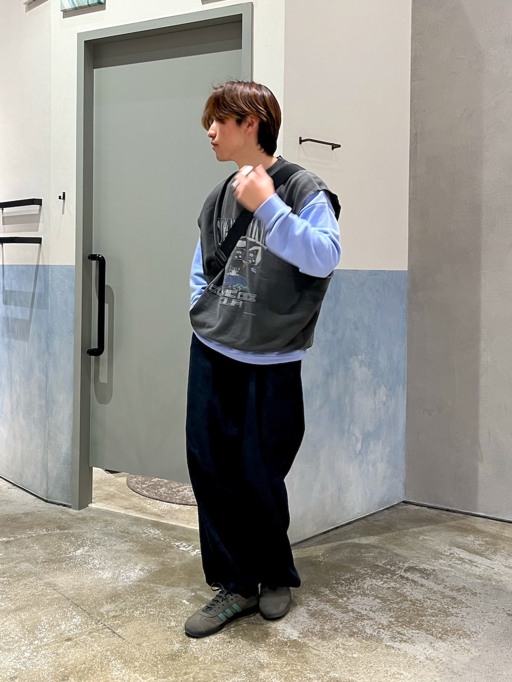 グレー系のスニーカー、ブルー系のデニムパンツ、ブルー系のスウェットを着用したメンズの冬コーディネートの2枚目の写真