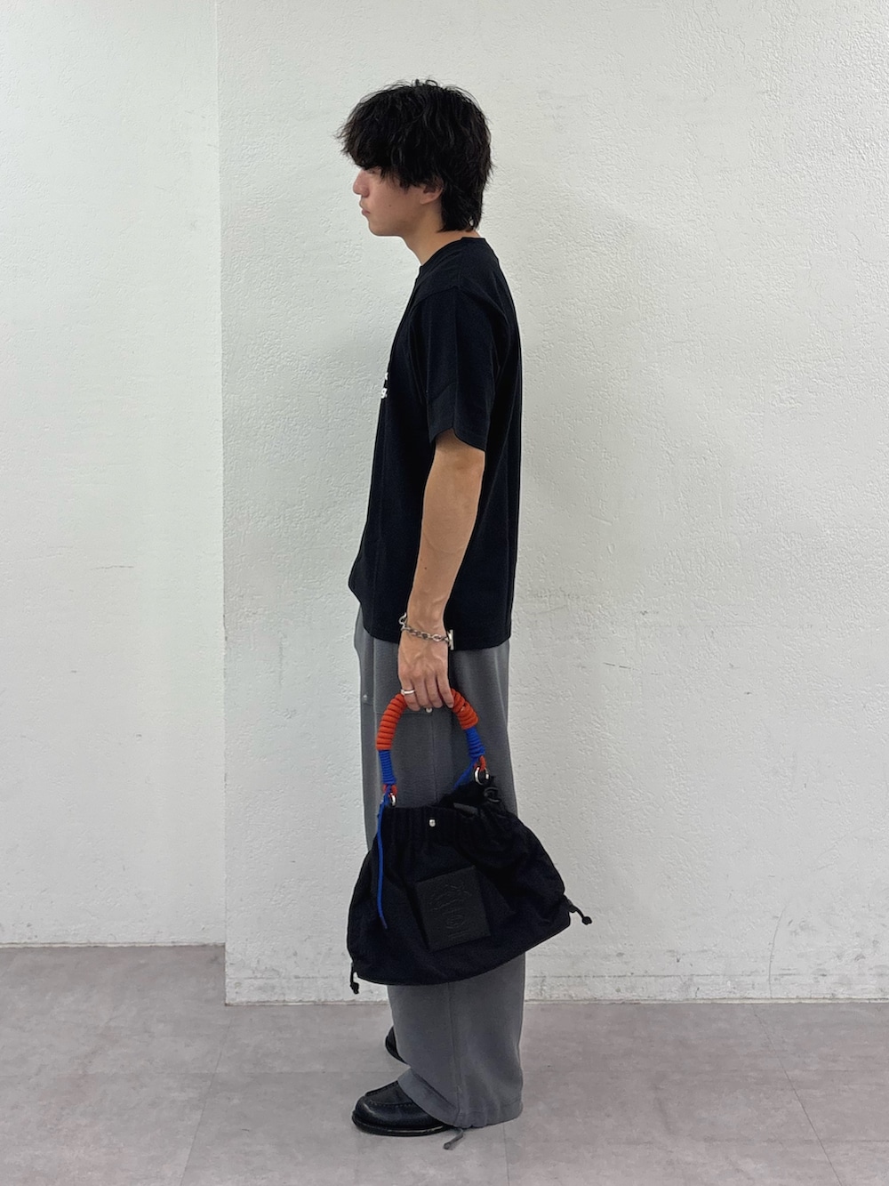 ブラック系のTシャツ/カットソー、グレー系のスウェットパンツ、ブラック系のトートバッグを着用したメンズの秋コーディネートの2枚目の写真
