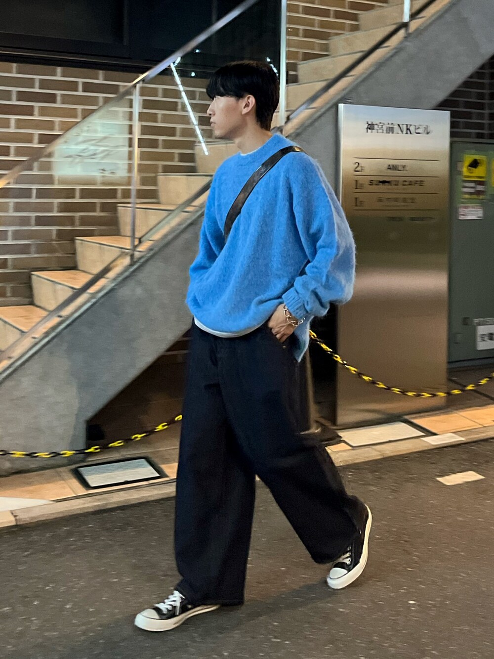 ブルー系のパンツ、ブルー系のニット/セーター、ブラック系のショルダーバッグを着用したメンズの秋コーディネートの2枚目の写真