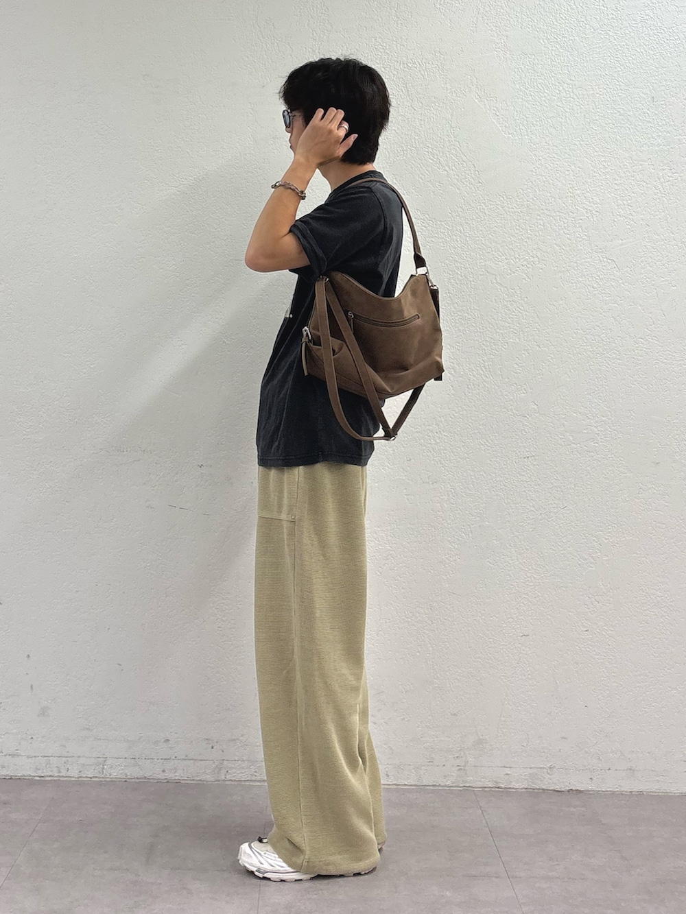 ブラック系のTシャツ/カットソー、ベージュ系のショルダーバッグ、ベージュ系のスウェットパンツを着用したメンズの夏コーディネートの2枚目の写真