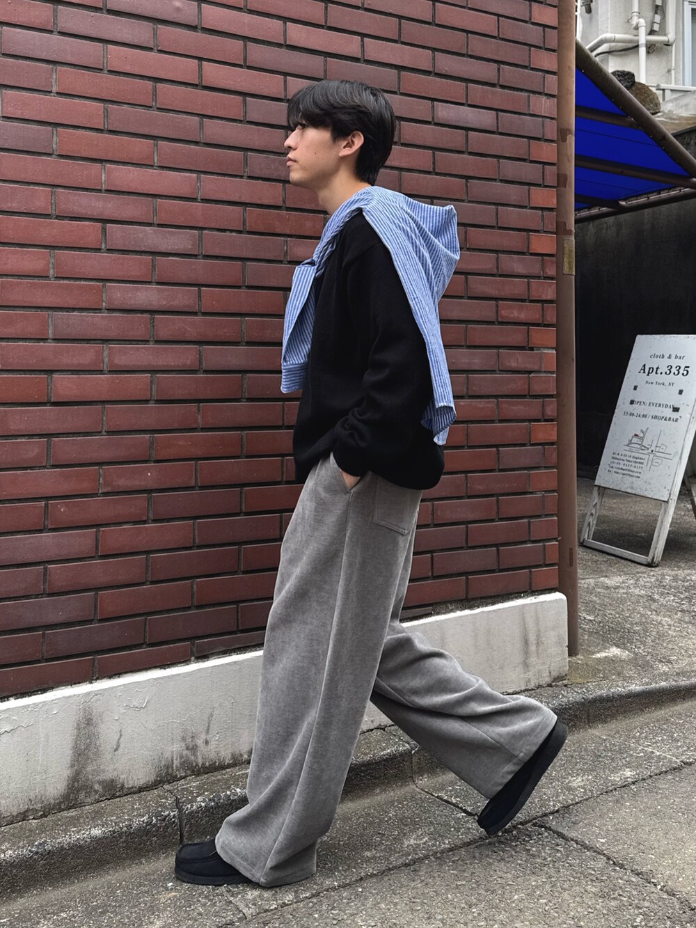 ブルー系のシャツ/ブラウス、ブラック系のニット/セーター、グレー系のその他パンツを着用したメンズの秋コーディネートの2枚目の写真