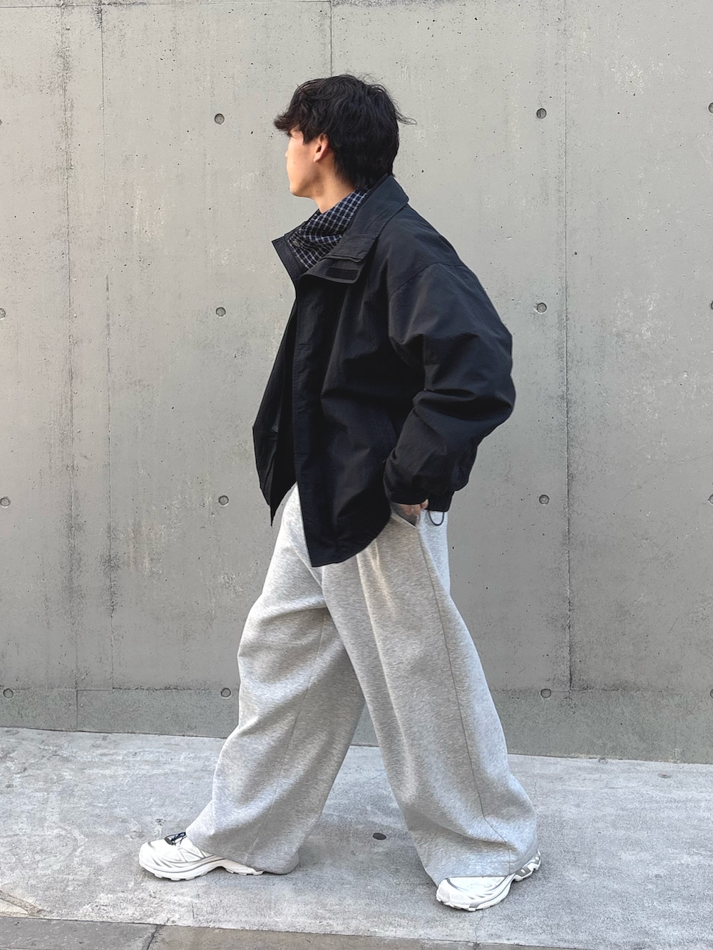 ブラック系のナイロンジャケット、ブルー系のパーカー、グレー系のその他パンツを着用したメンズの冬コーディネートの2枚目の写真