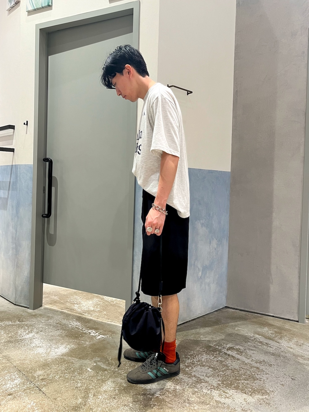 グレー系のTシャツ/カットソー、ブラック系のパンツ、ブラック系のショルダーバッグを着用したメンズの夏コーディネートの2枚目の写真