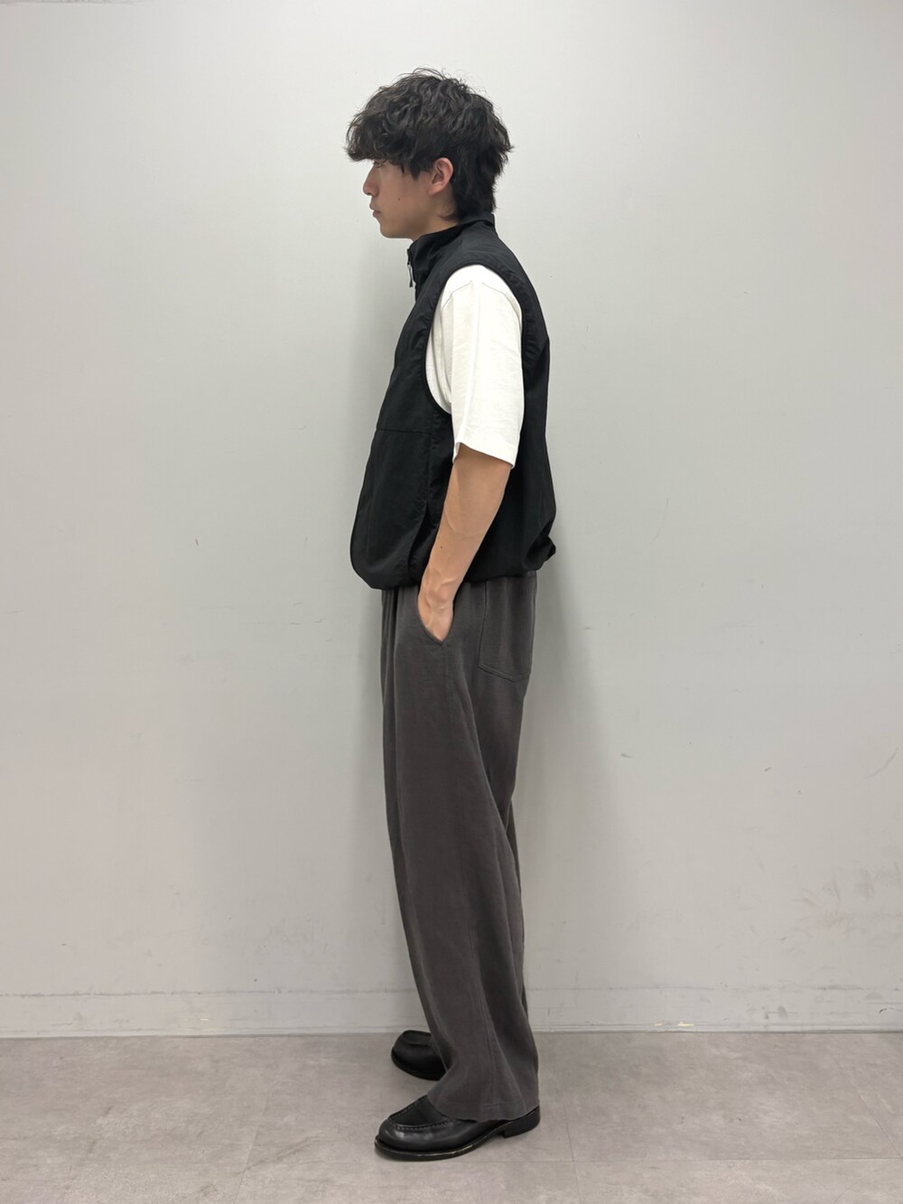 ブラック系のベスト、ホワイト系のTシャツ/カットソー、グレー系のその他パンツを着用したメンズの春コーディネートの2枚目の写真