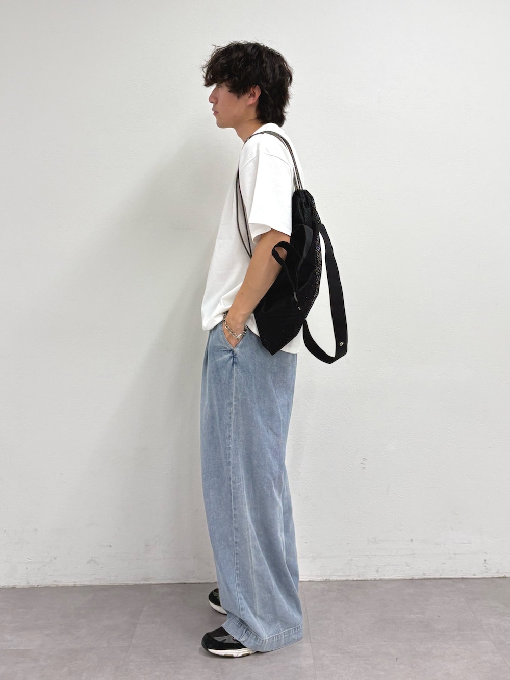 ホワイト系のTシャツ/カットソー、ブラック系のトートバッグ、ブルー系のデニムパンツを着用したメンズの夏コーディネートの2枚目の写真