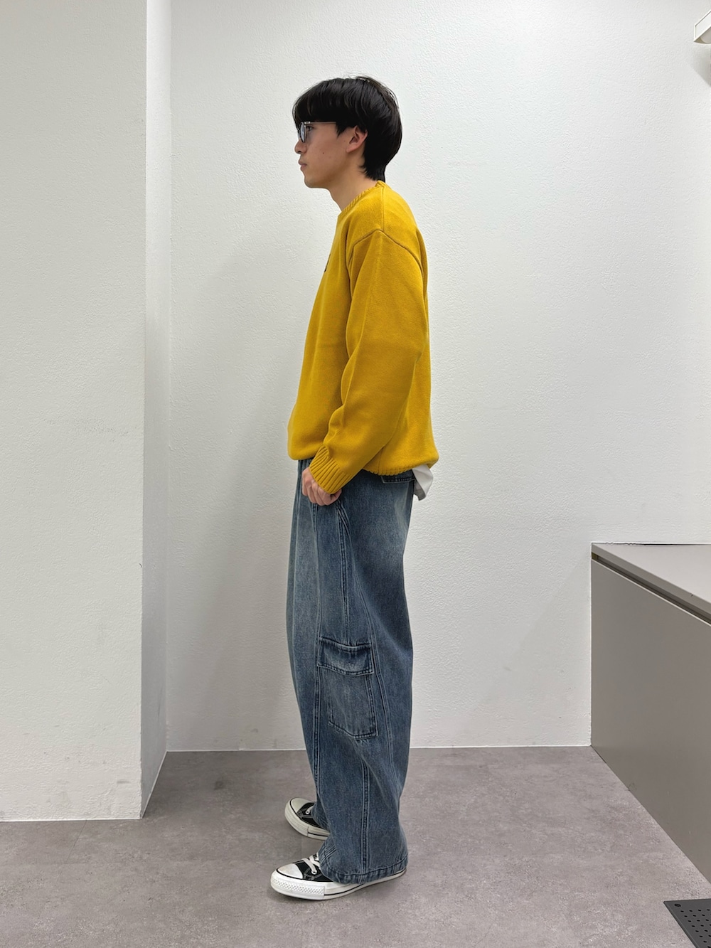 イエロー系のニット/セーター、ブルー系のカーゴパンツを着用したメンズの冬コーディネートの2枚目の写真