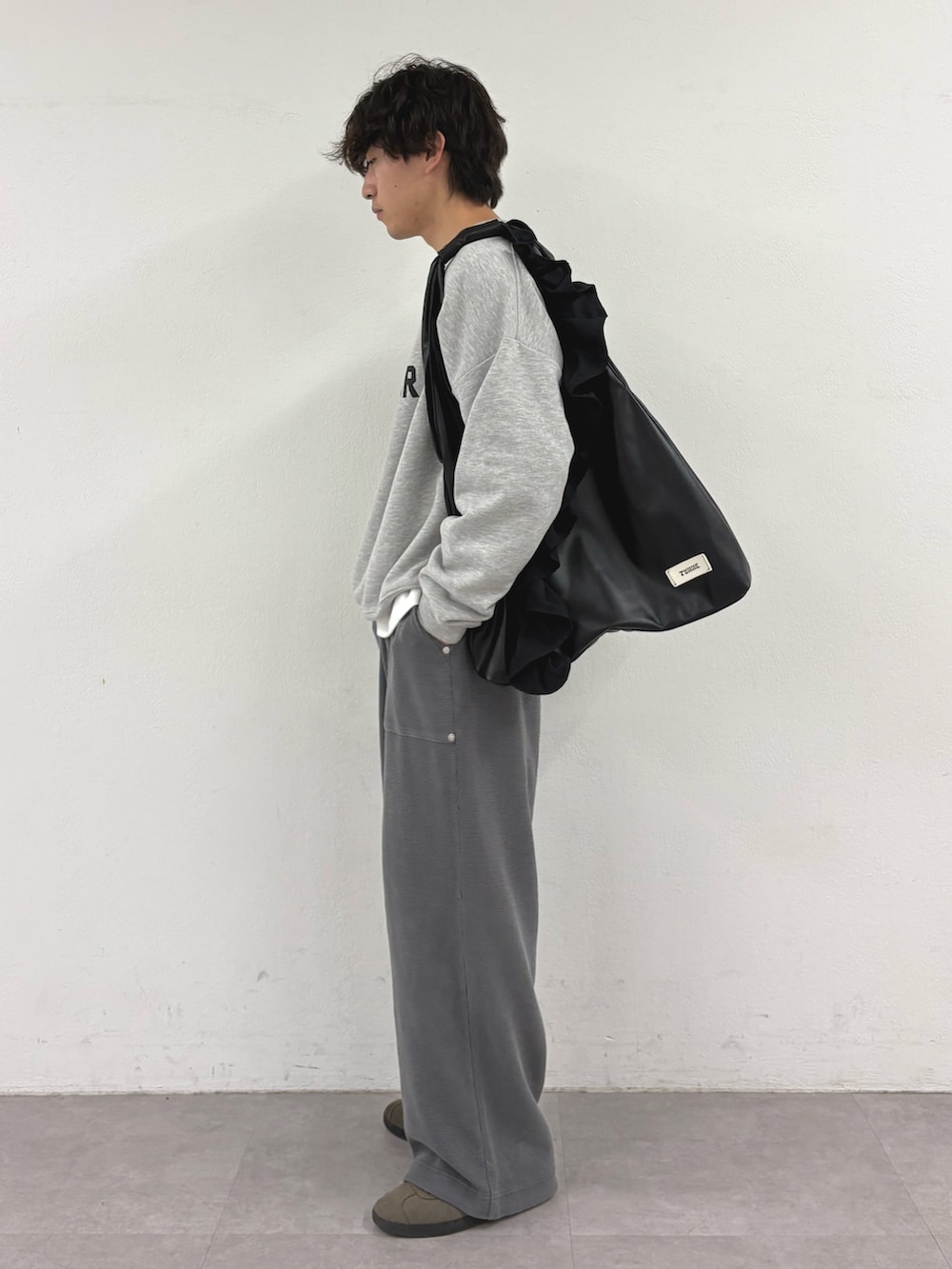グレー系のスウェット、ブラック系のトートバッグ、グレー系のスウェットパンツを着用したメンズの秋コーディネートの2枚目の写真