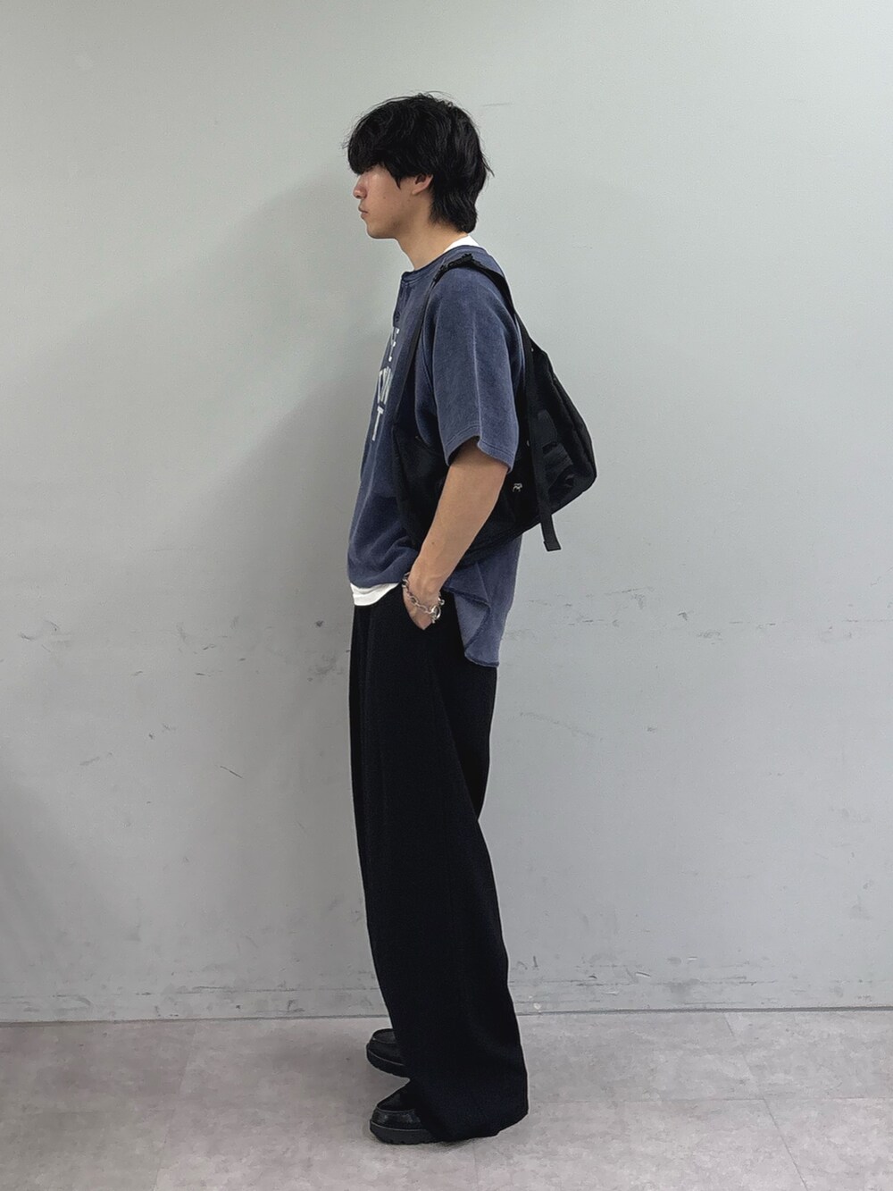 ブラック系のショルダーバッグ、ブラック系のスラックス、ブルー系のTシャツ/カットソーを着用したメンズの春コーディネートの2枚目の写真