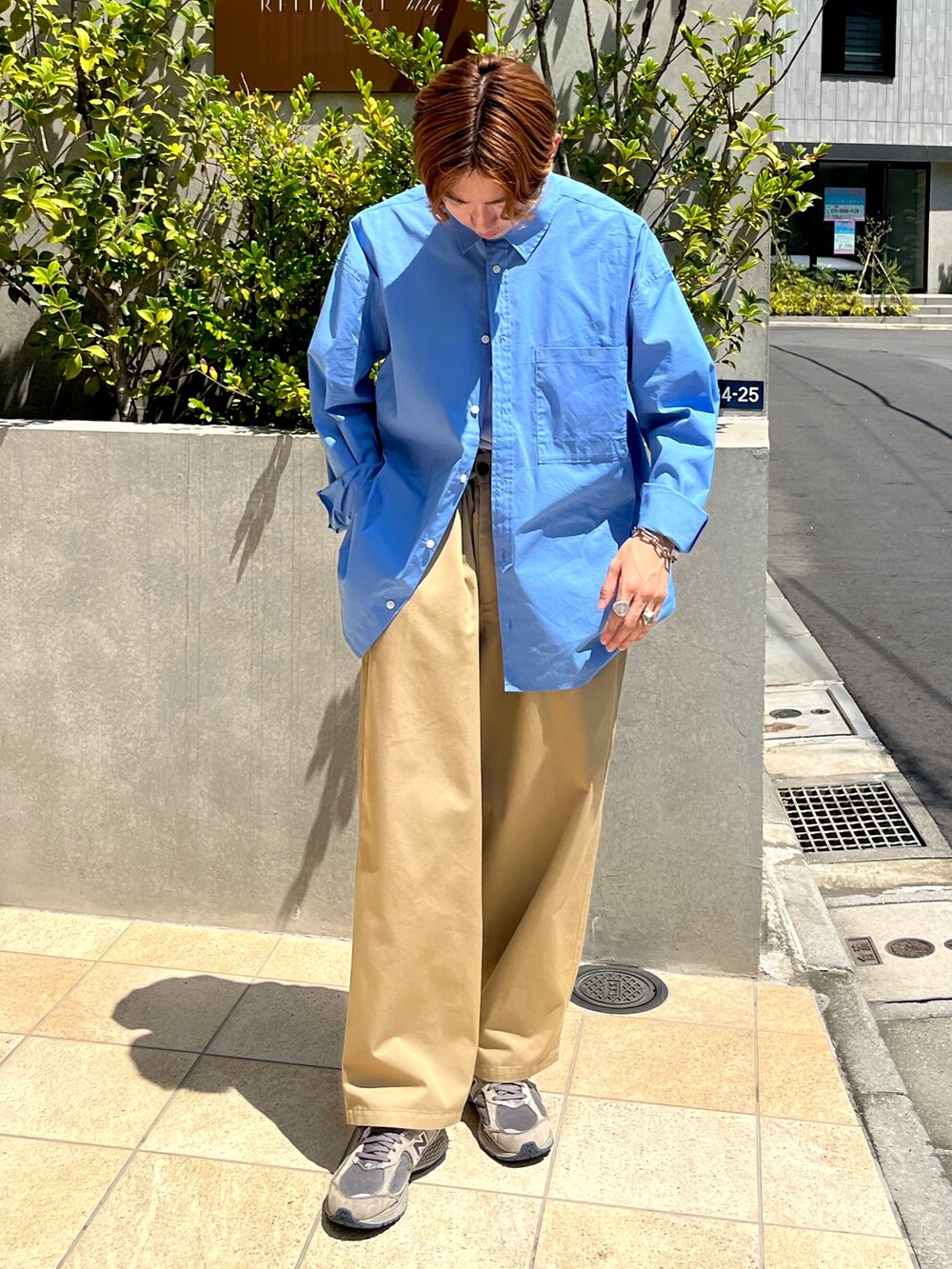 ブルー系のシャツ/ブラウス、ベージュ系のチノパンツ、グレー系のスニーカーを着用したメンズの夏コーディネートの2枚目の写真