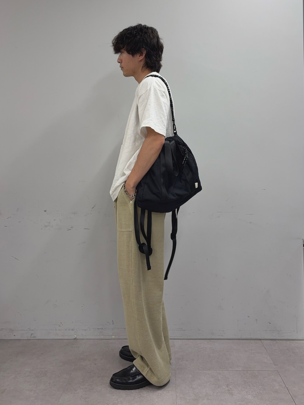 ホワイト系のTシャツ/カットソー、ブラック系のトートバッグ、ベージュ系のスウェットパンツを着用したメンズの夏コーディネートの2枚目の写真