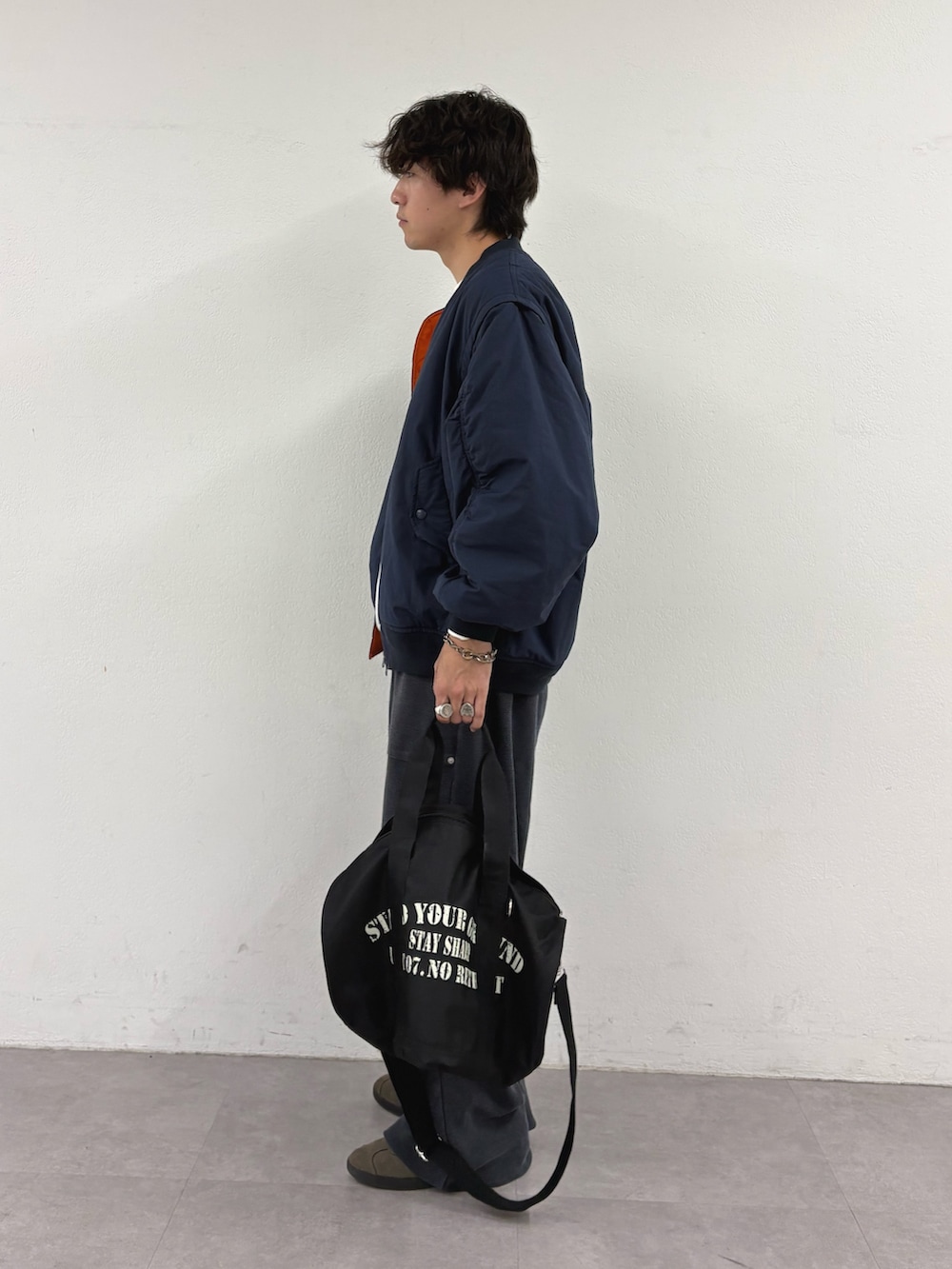 ブルー系のMA-1、ホワイト系のTシャツ/カットソー、ブラック系のスウェットパンツを着用したメンズの秋コーディネートの2枚目の写真