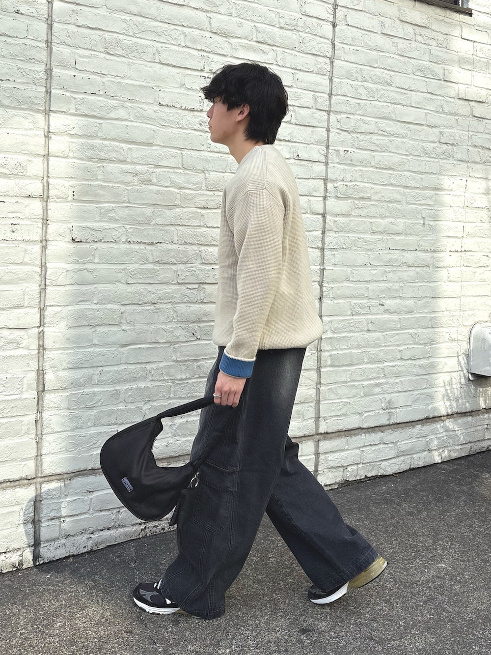 ホワイト系のニット/セーター、ブラック系のカーゴパンツを着用したメンズの冬コーディネートの2枚目の写真