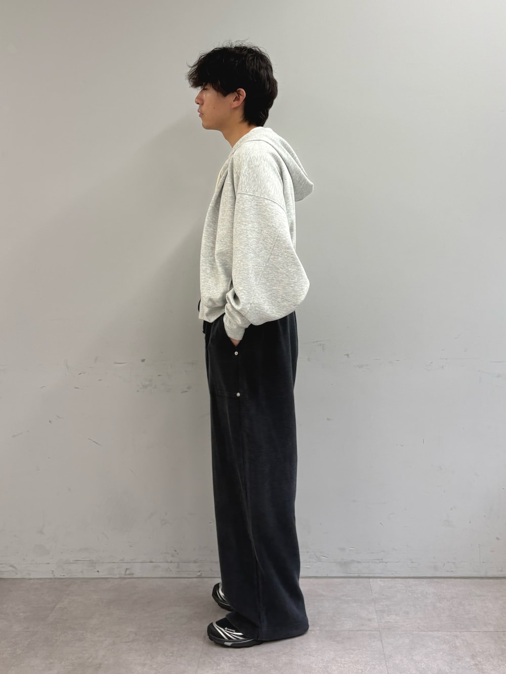 グレー系のパーカー、ホワイト系のTシャツ/カットソー、ブラック系のスウェットパンツを着用したメンズの秋コーディネートの2枚目の写真