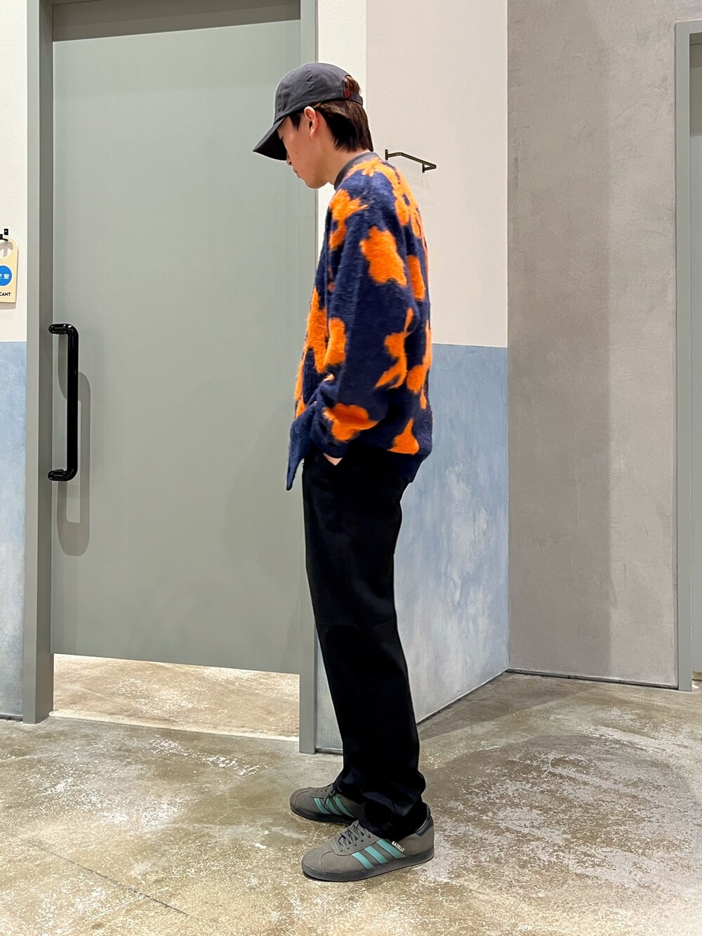 グレー系のスニーカー、ブラック系のパンツ、ブルー系のカーディガン/ボレロを着用したメンズの冬コーディネートの2枚目の写真